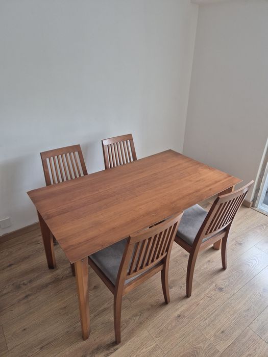 Mesa de jantar castanho claro com 4 cadeiras com assento almofadado