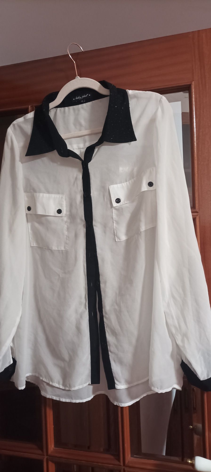 Camisa com faixa preta e o resto branco e brilhante no colarinho
