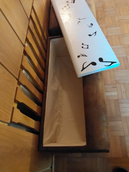 Siedzisko, szeroka pufa z dużą skrytkę, pianino, motyw nut muzycznych