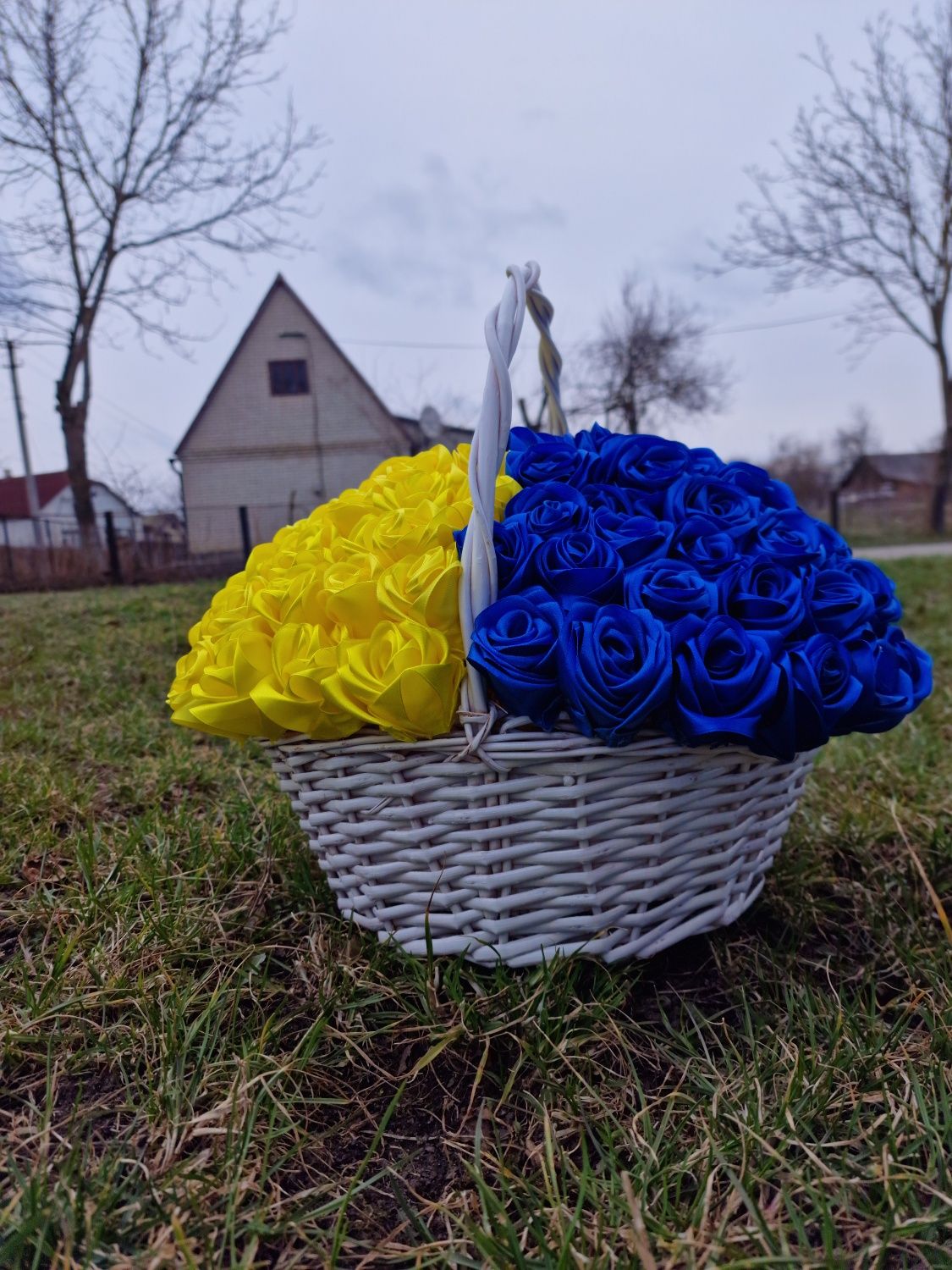 122 троянди із стрічки у плетеному кошику