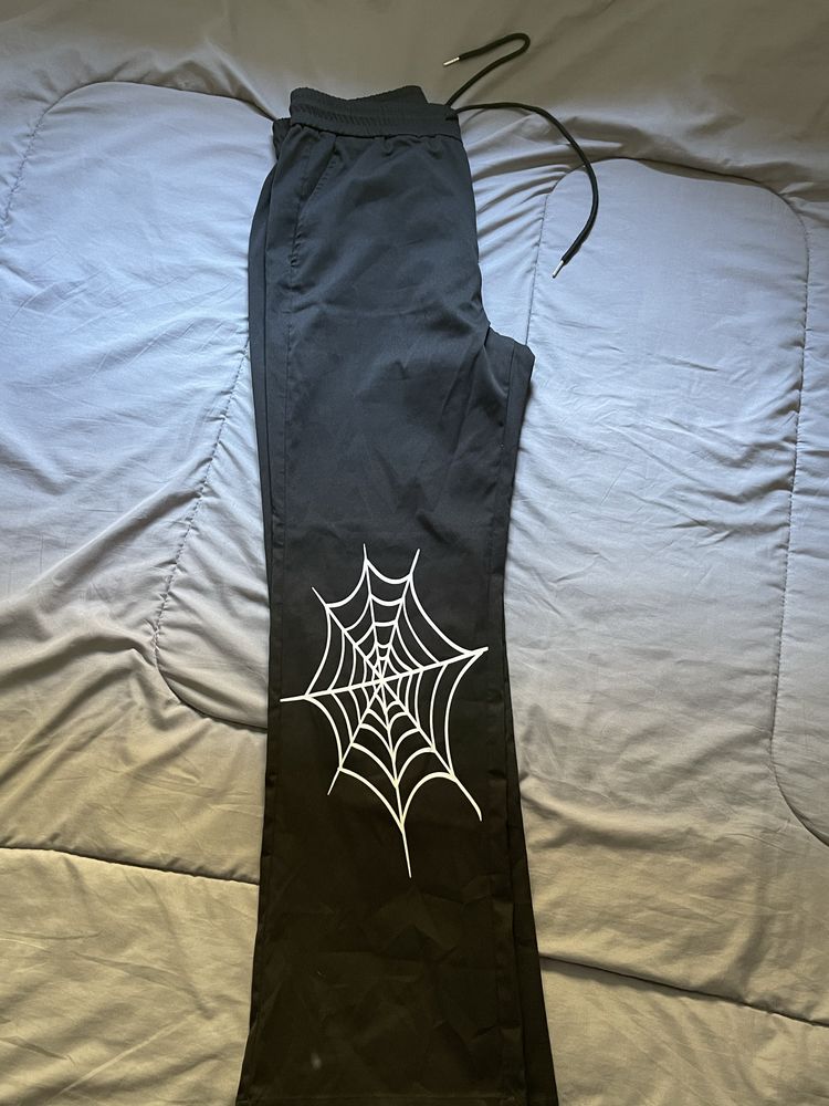 Calças pretas com desenho de aranha