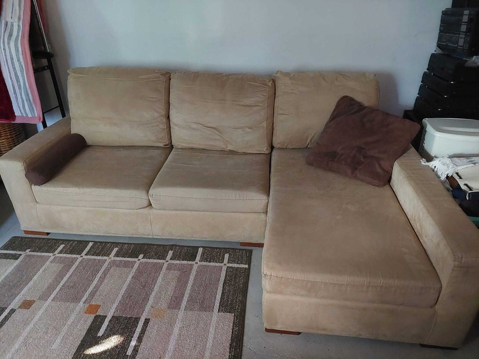 Sofá côr bege com chaise long  à esquerda .