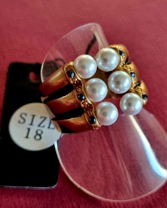 Anel dourado e preto, em aço, com 6 pérolas e 6 pedrinhas pretas. T18