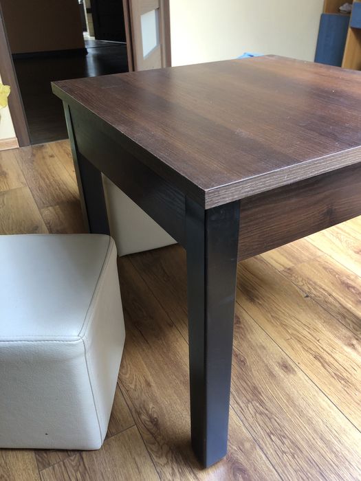 Brązowy stolik kawowy i dwie pufki białe