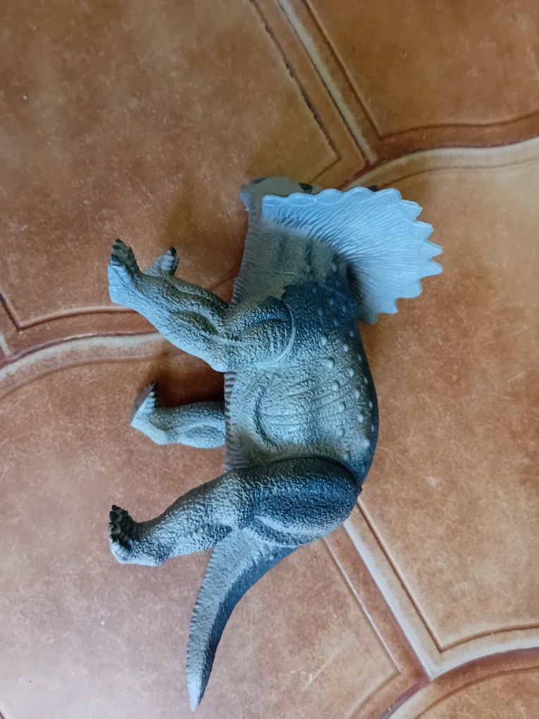 Brinquedos plásticos do dinossauro com pés móveis