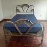 Cama com estrutura metálica e colchão.