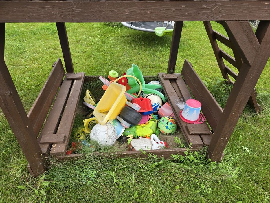 Drewniany plac zabaw z domkiem, zjeżdżalnią, huśtawką i ścianką wspina