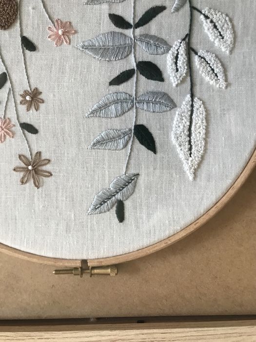 Quadros bordados à mão com motivos de flores.