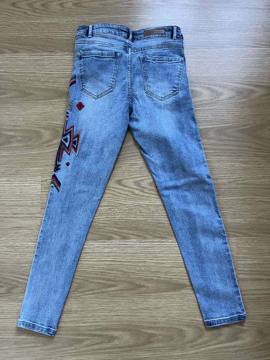 Calças de ganga azul clara com uma aplicação da Lefties