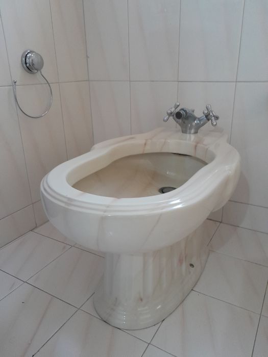 Louça de casa de banho de cor rosa e beje.
