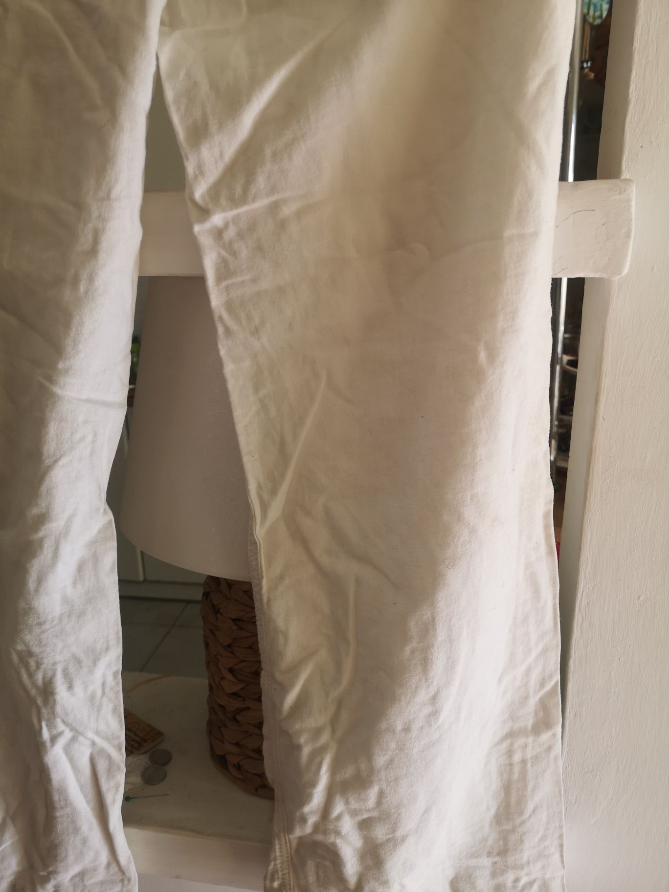 Białe lniane spodnie modne w tym sezonie z szerszym nogawkami