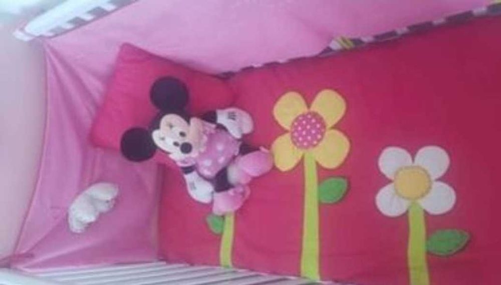 Cama de bebé rosa com colchão