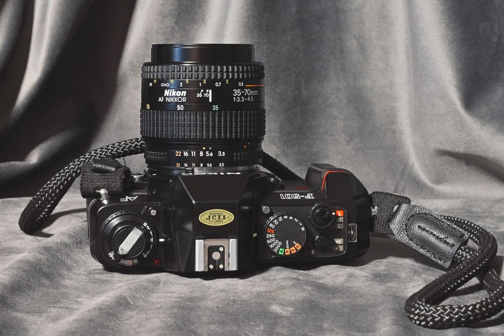 Nikon z obiektywem, plus lampa, pasek i baterie