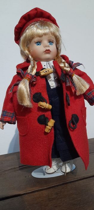 Boneca loiça e pano, com suporte em metal