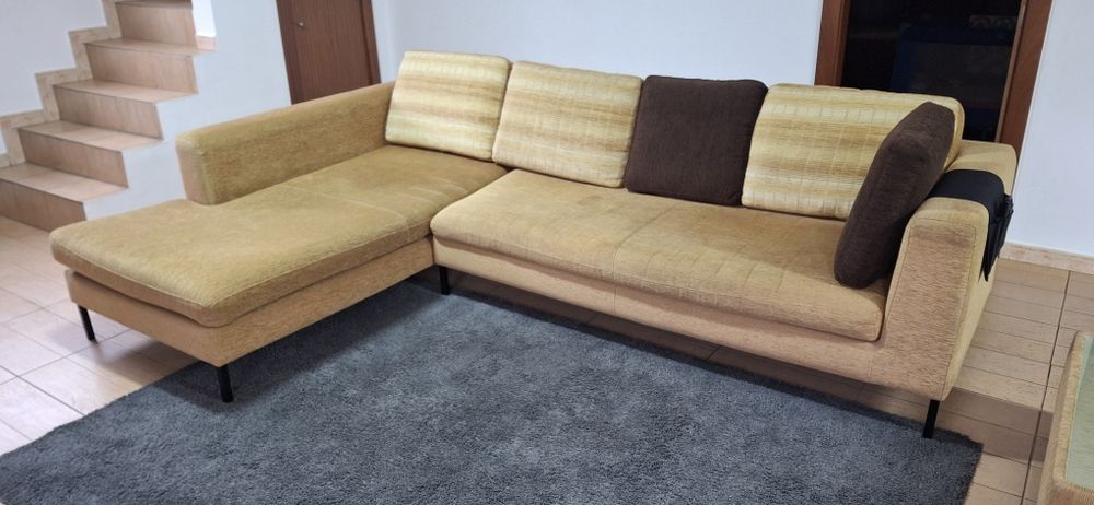Sofá com chaise longue e mesa.