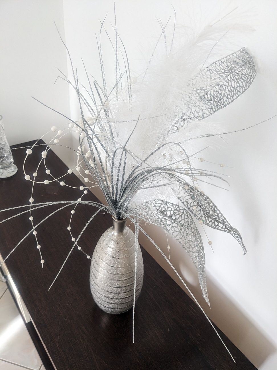 Srebrny wazon ze sztuczną ozdobną trawą