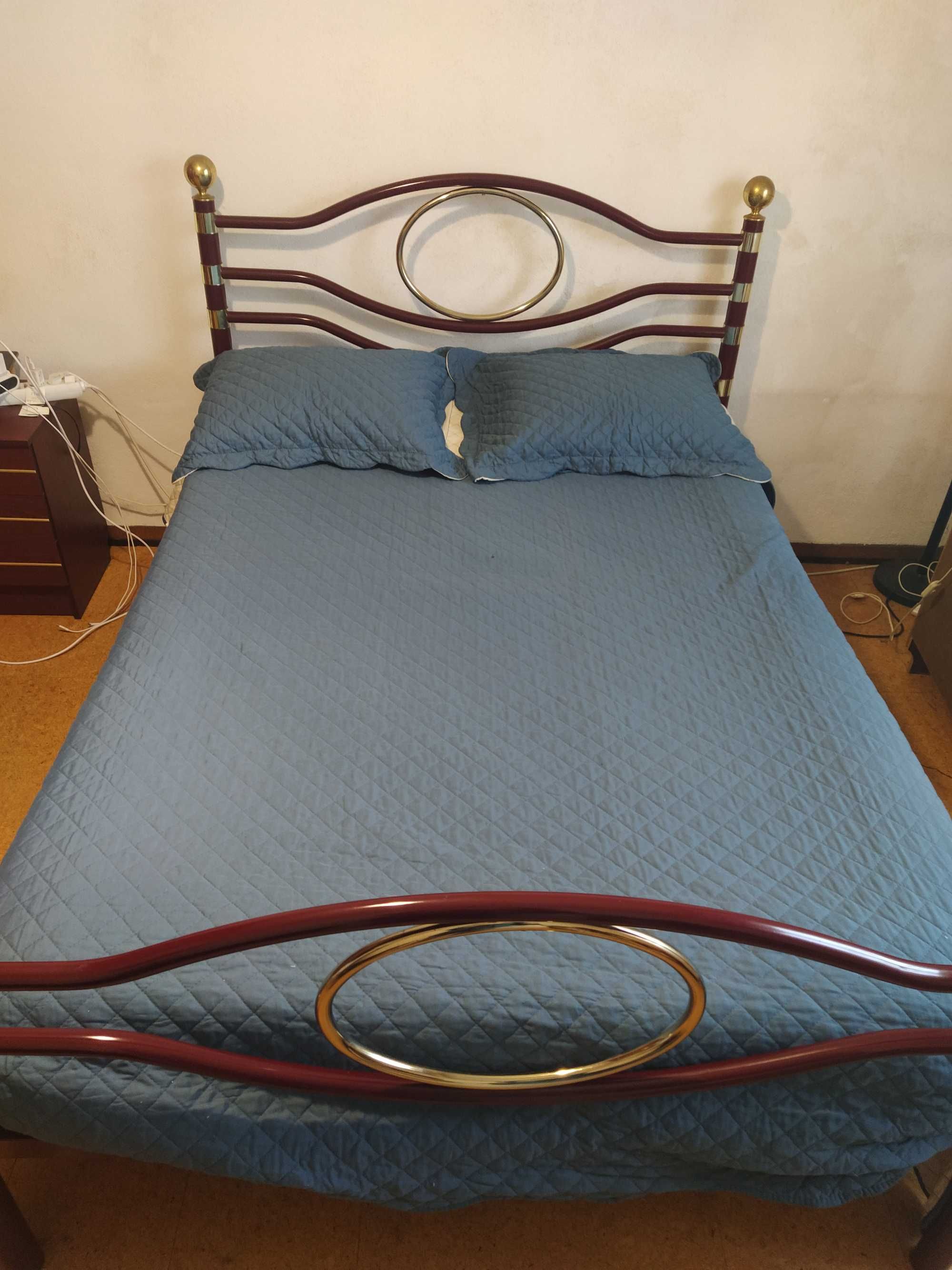Cama de Casal em ferro com colchão e mesas de cabeceira.