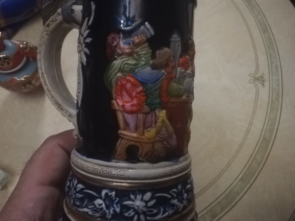 Caneca Alemã antiga com música e figuras em relevo.