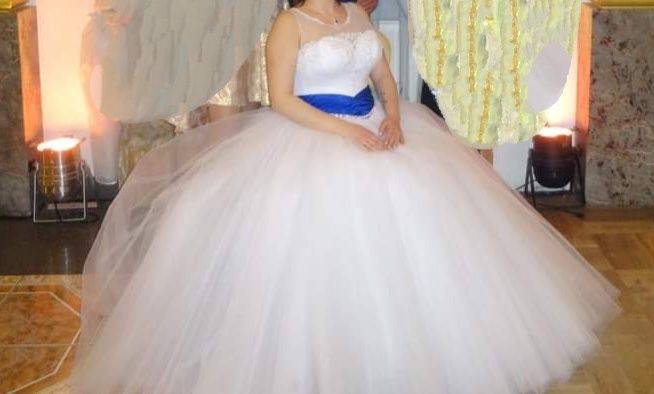 Piękna suknia ślubna typ księżniczki przepasana szafirowym pasem