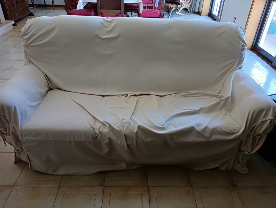 Sofá de três lugares e 2 poltronas em couro castanho.