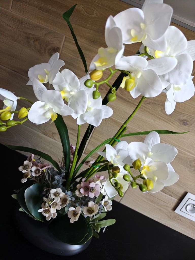 Sztuczny storczyk orchidea w czarnej ceramicznej doniczce