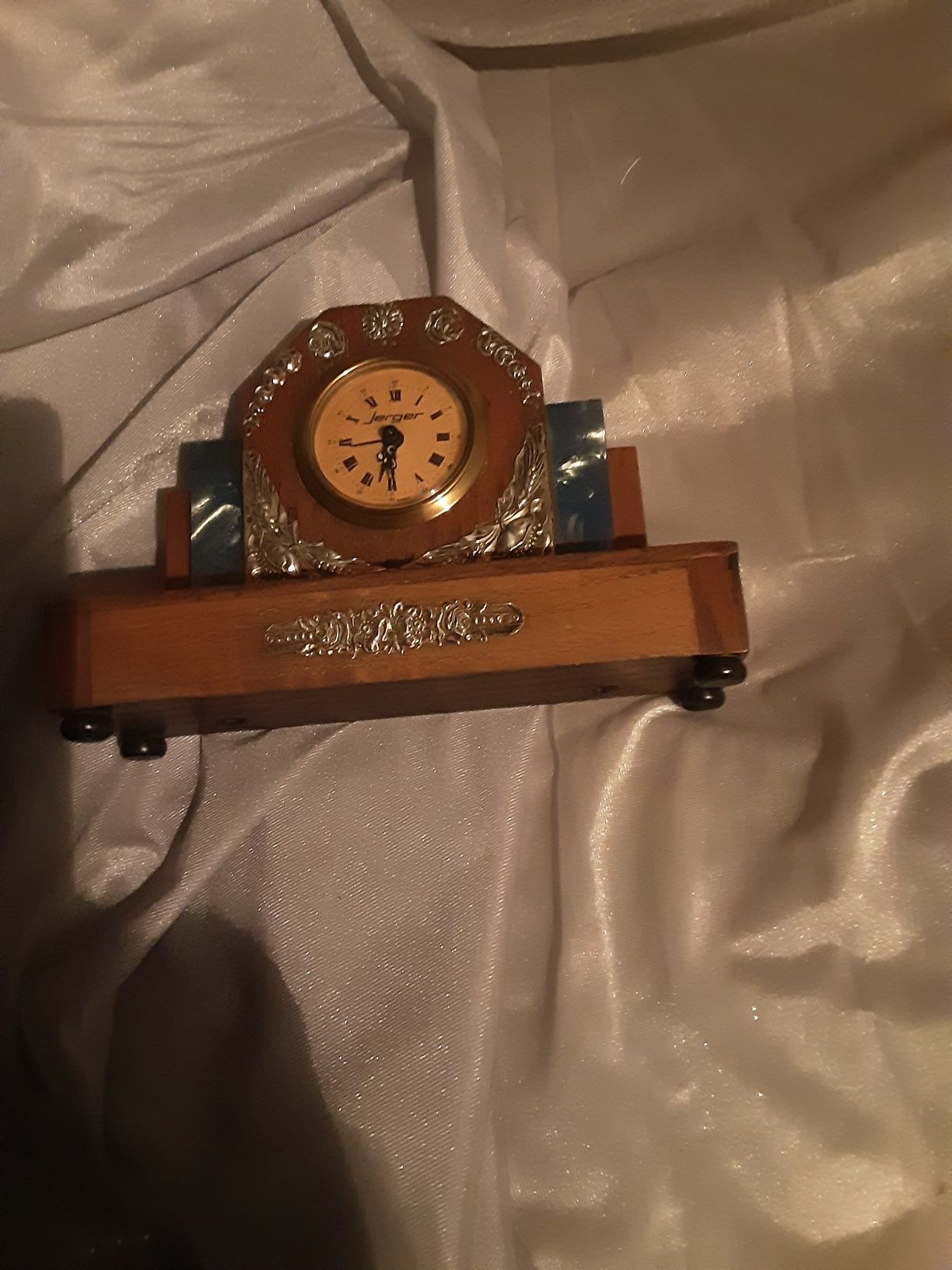 Relógio em madeira preciosa com aplicações de prata e a funcionar.