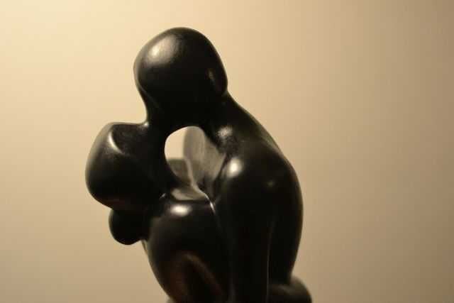 Escultura com figura de casal e base em pedra