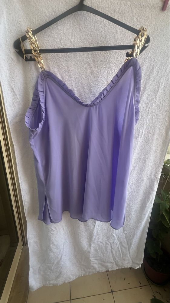 Blusa com alças de metal douradas.