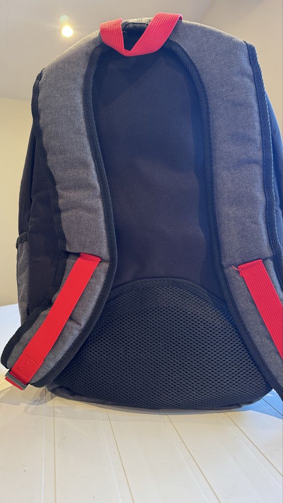 Mochila preta com os fechos em vermelho