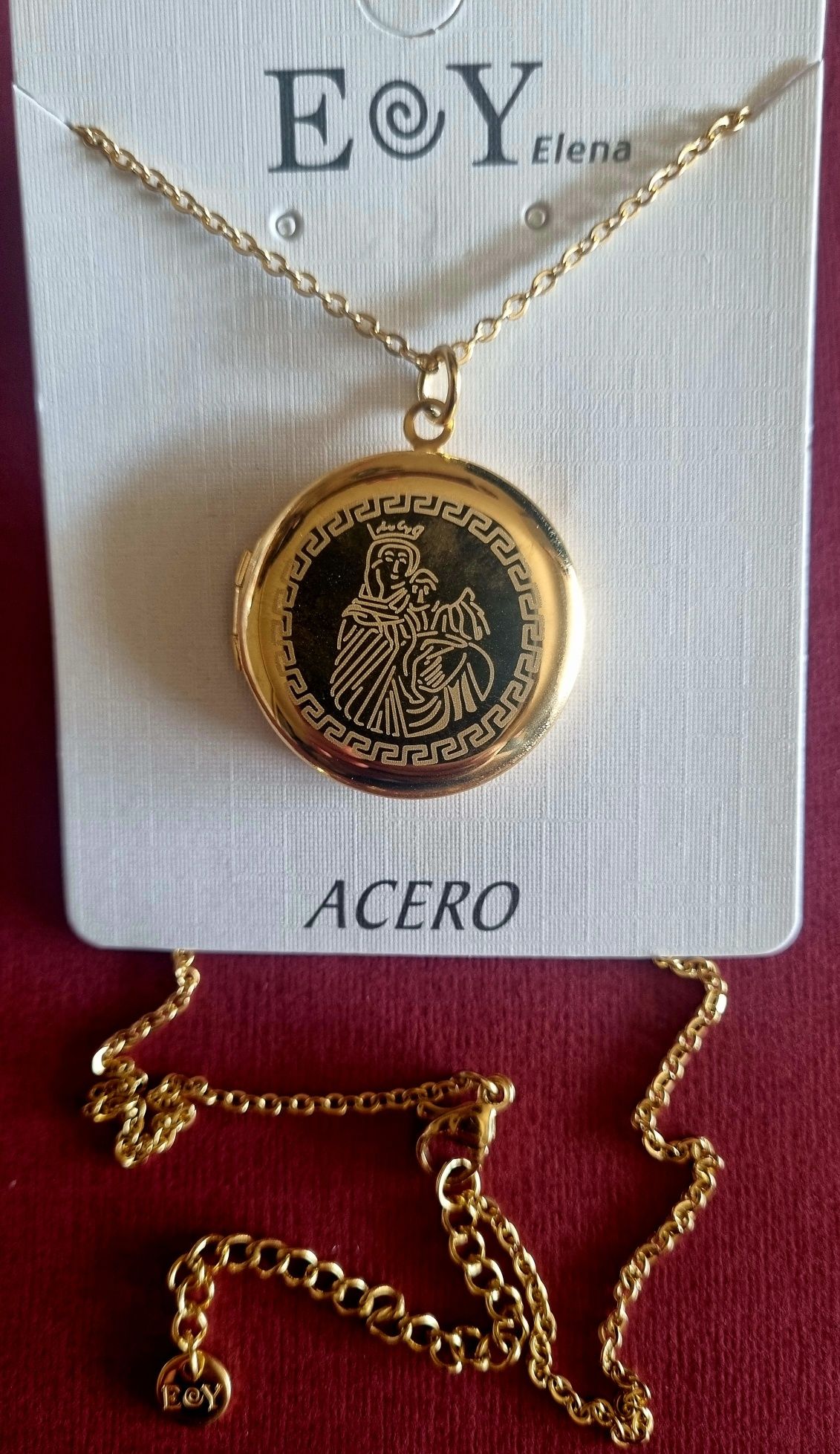 Colar/relicário dourado, em aço, com a Nossa Senhora. Tem extensor