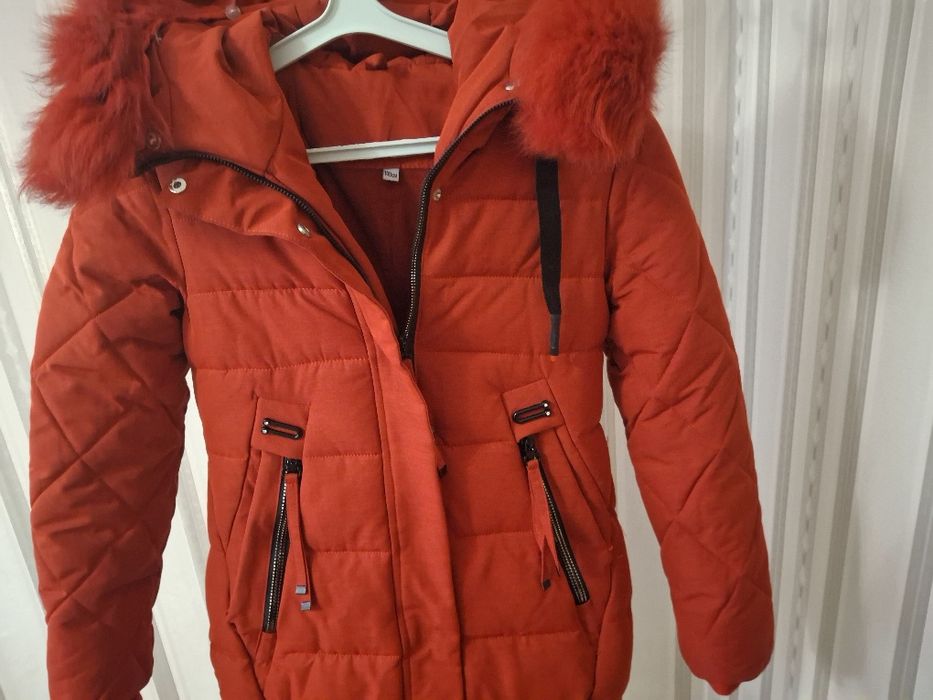 Куртка-парка червоного кольору з капюшоном, оздобленим хутром.