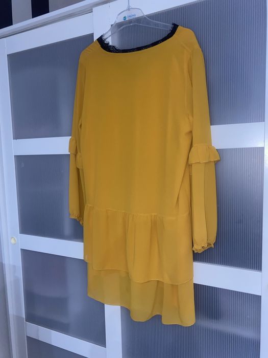 Musztardowa sukienka z koronkowym dekoltem i falbankami