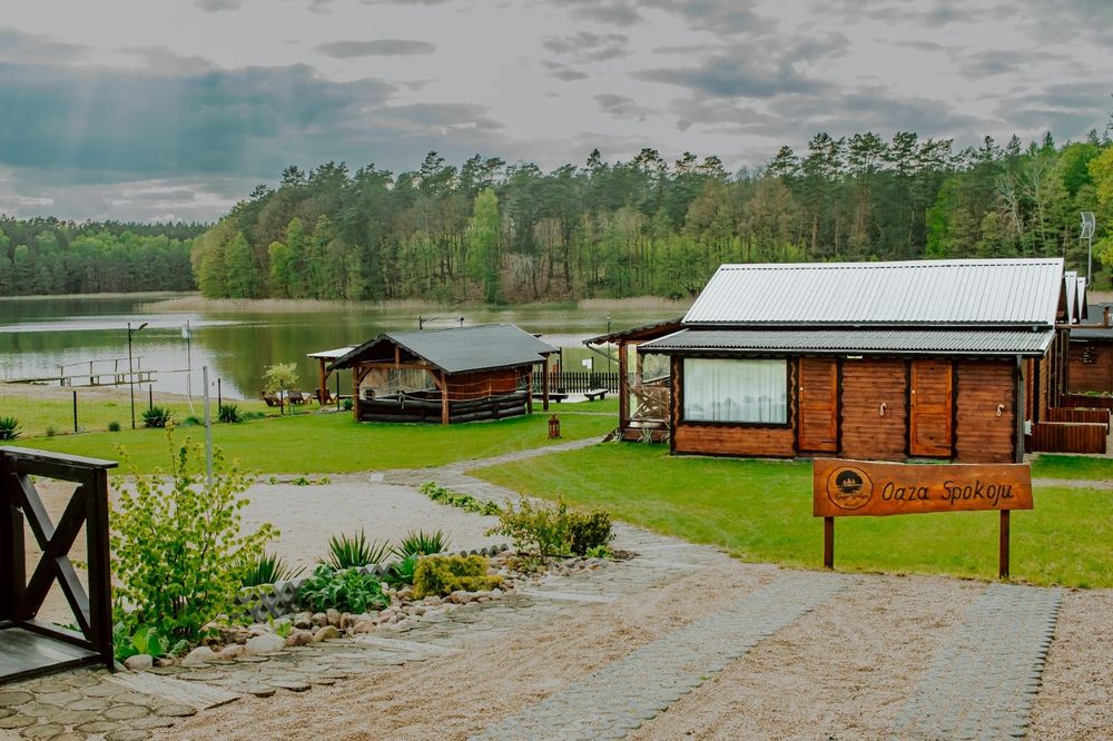 Domek nad jeziorem z jacuzzi, sauną i strefą masażu .