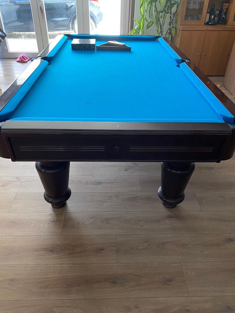 Mesa de bilhar com tacos e bolas