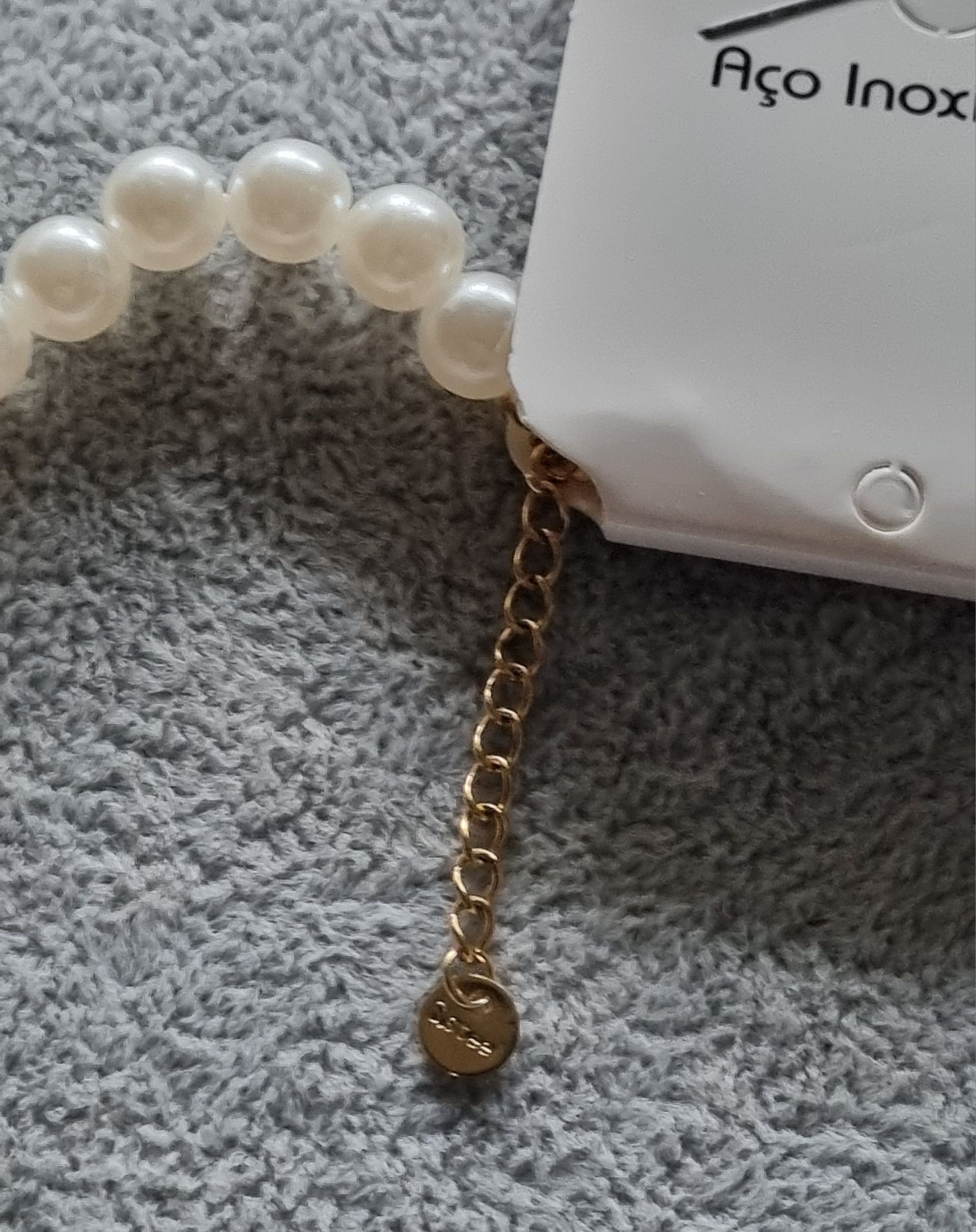 Colar/choker de pérolas com acabamento dourado em açol. Tem extensor