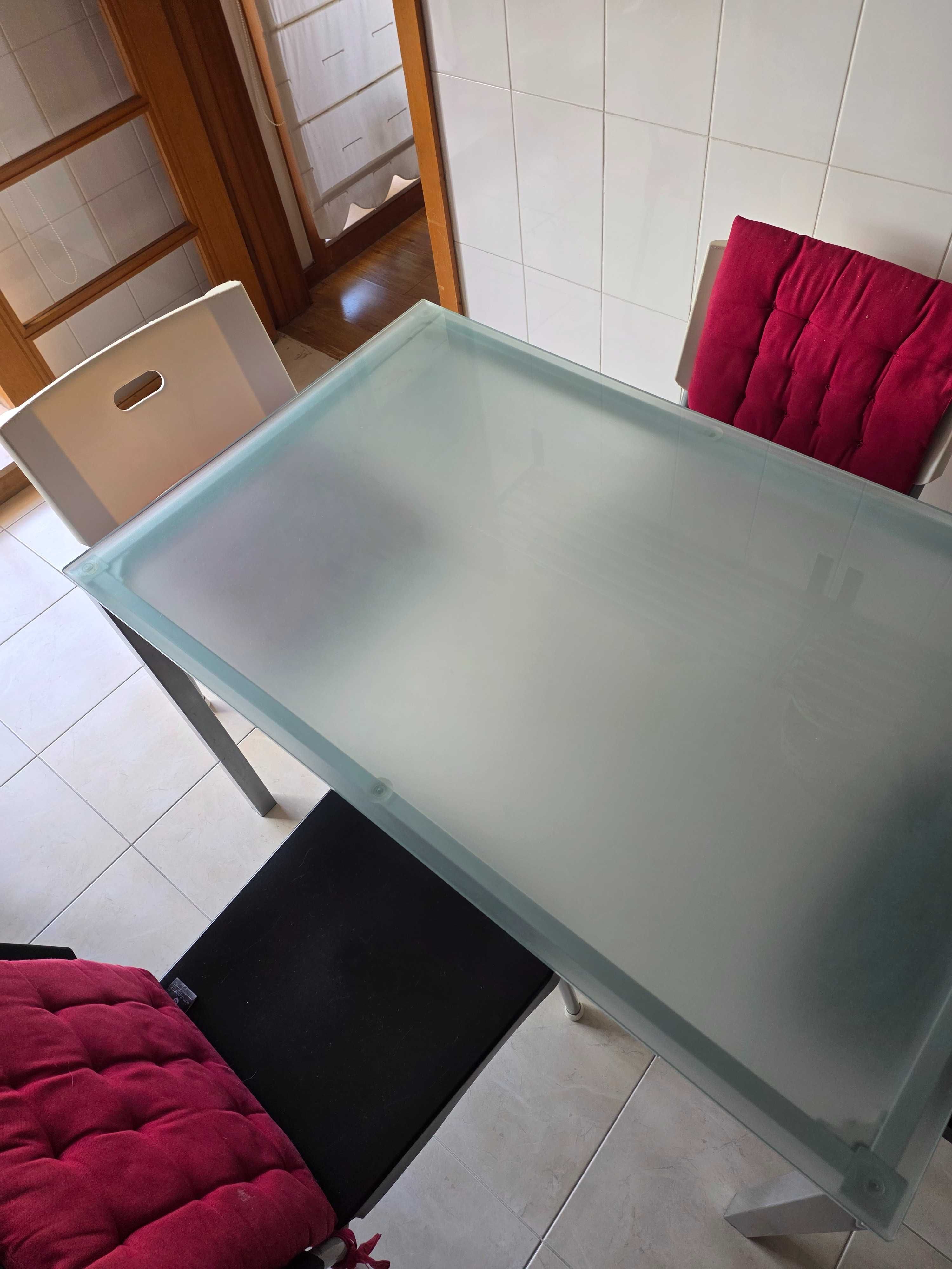 Mesa de vidro com cadeiras.