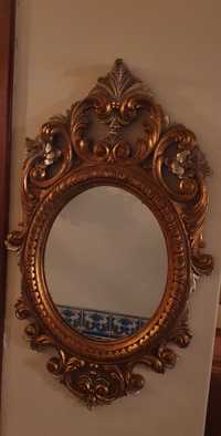 Espelho de talha dourada oval.