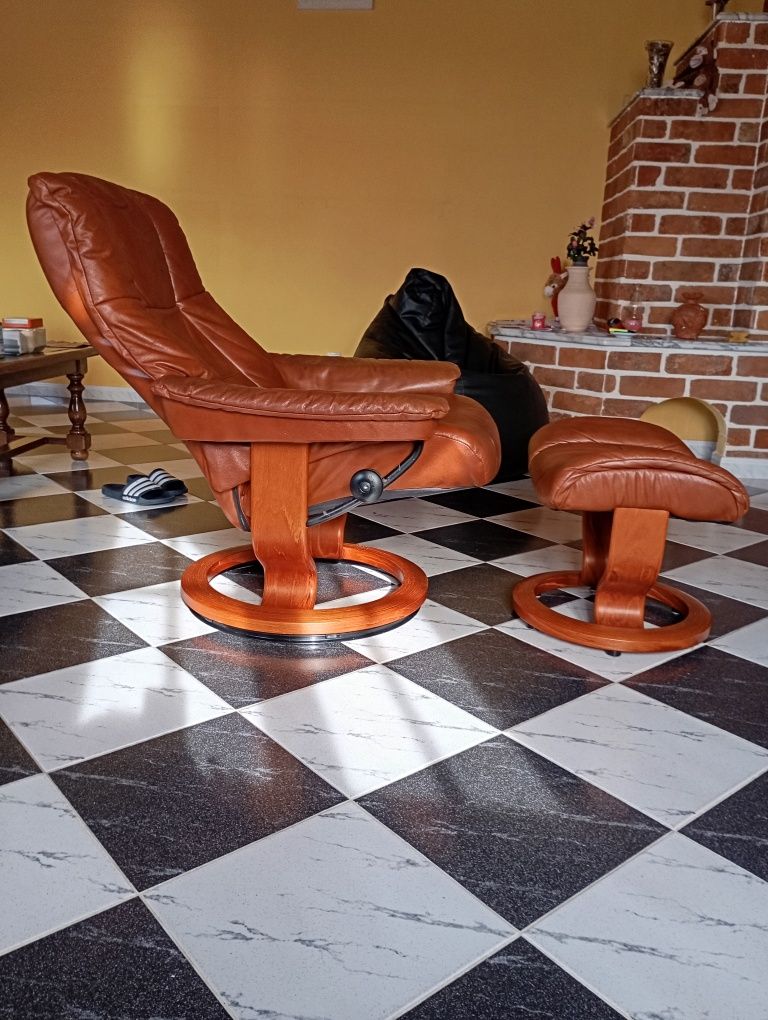 Cadeirão castanho com apoio de pés em couro castanho