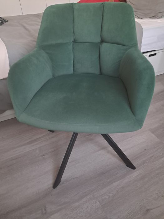 Cadeira giratória verde com pernas de aço preto.