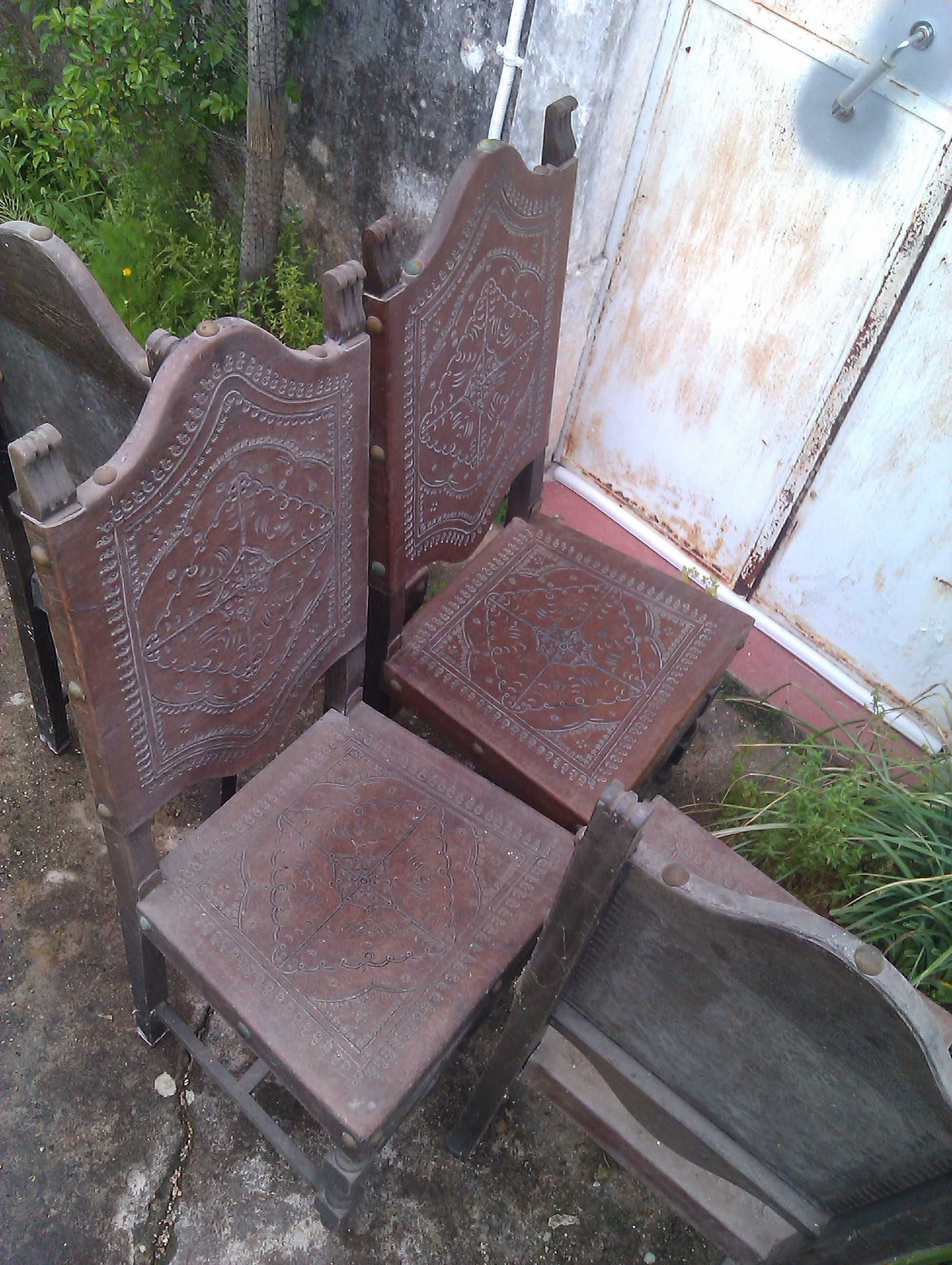 Cadeiras em mogno e couro trabalhado.