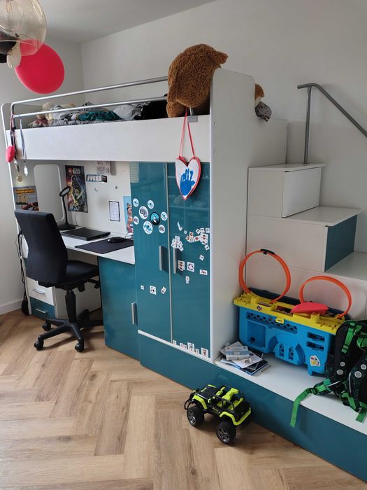 Łóżko piętrowe z biurkiem plus fotel.