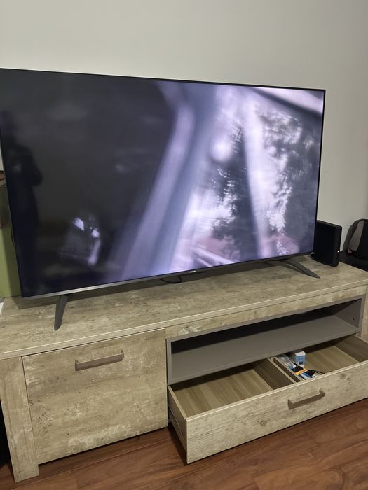 Móvel TV cor neutra com gavetas e prateleira interna.