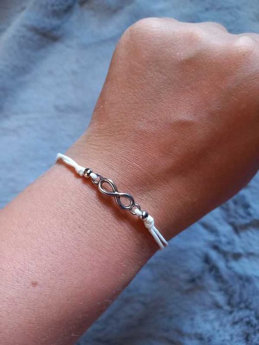 bransoletka z białą, regulowaną nitką i znakiem nieskończoności