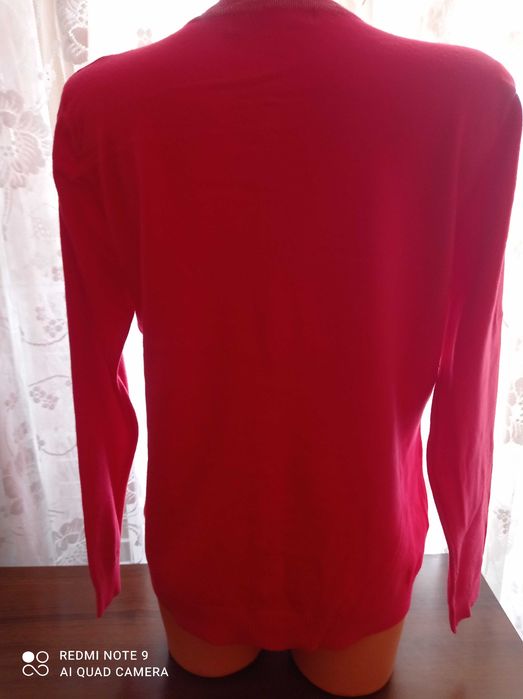 Duży ładny czerwony, damski sweterek z ozdobnym zapięciem.