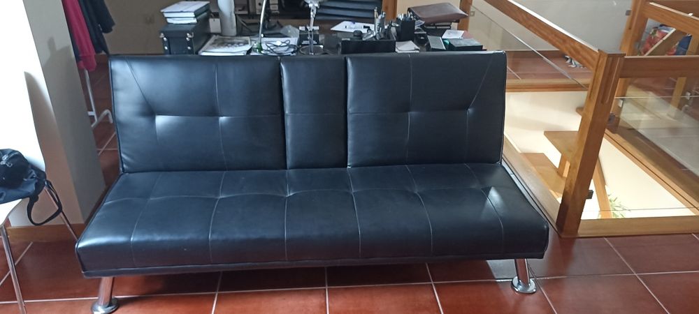 Sofá cama em pele sintética com porta copos central.