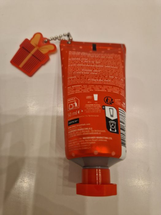 Cynamonowy krem do rąk Sence z breloczkiem w kształcie prezentu.