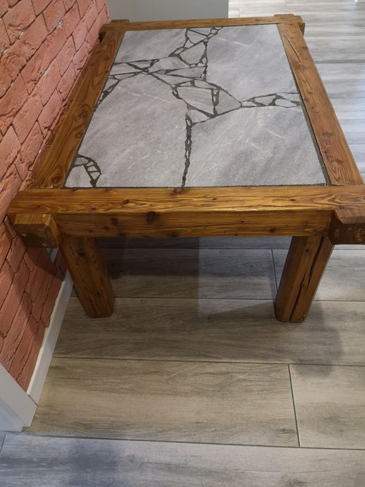 Stół z drewnianych belek z blatem marmurowym.