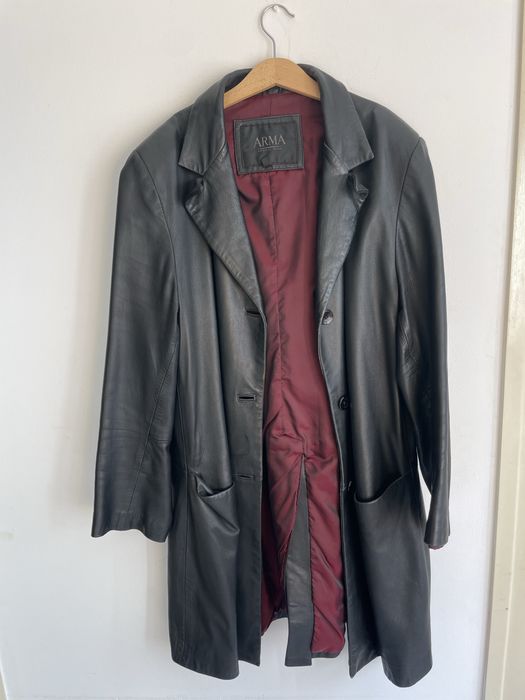 Casaco comprido de cabedal preto.