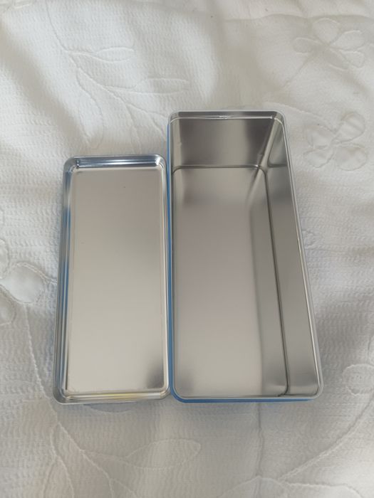 Caixa metálica com personagens da série de banda desenhada As Aventura