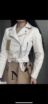 Женская куртка косуха короткая из эко-кожи молочного цвета.